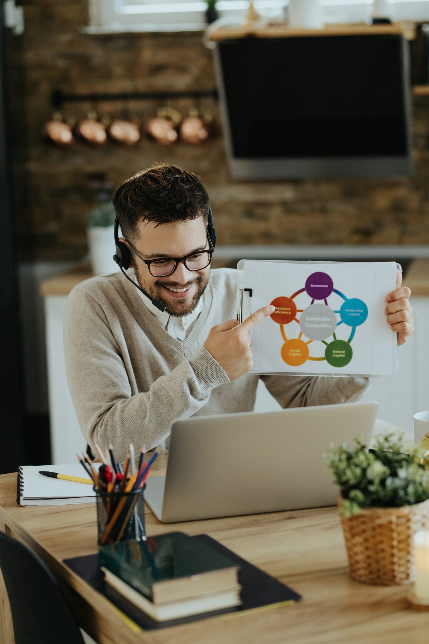 Happy entrepreneur analyzing business chart during web conferenc